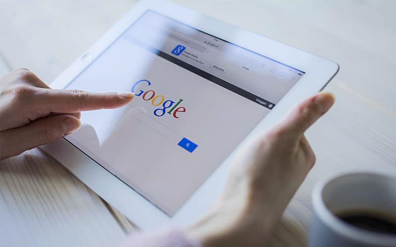 Persona usando tablet para buscar en Google.